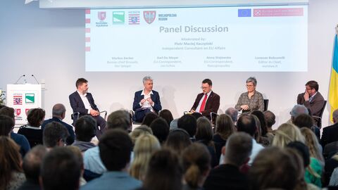 Panelisten im Gespräch Teilnehmende sitzen zusammen und unterhalten sich
